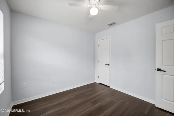 an empty room with a window and wooden floor