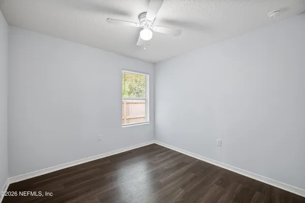 a view of an empty room with wooden floor