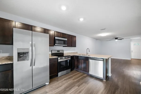 a kitchen with stainless steel appliances granite countertop a stove a sink and a refrigerator