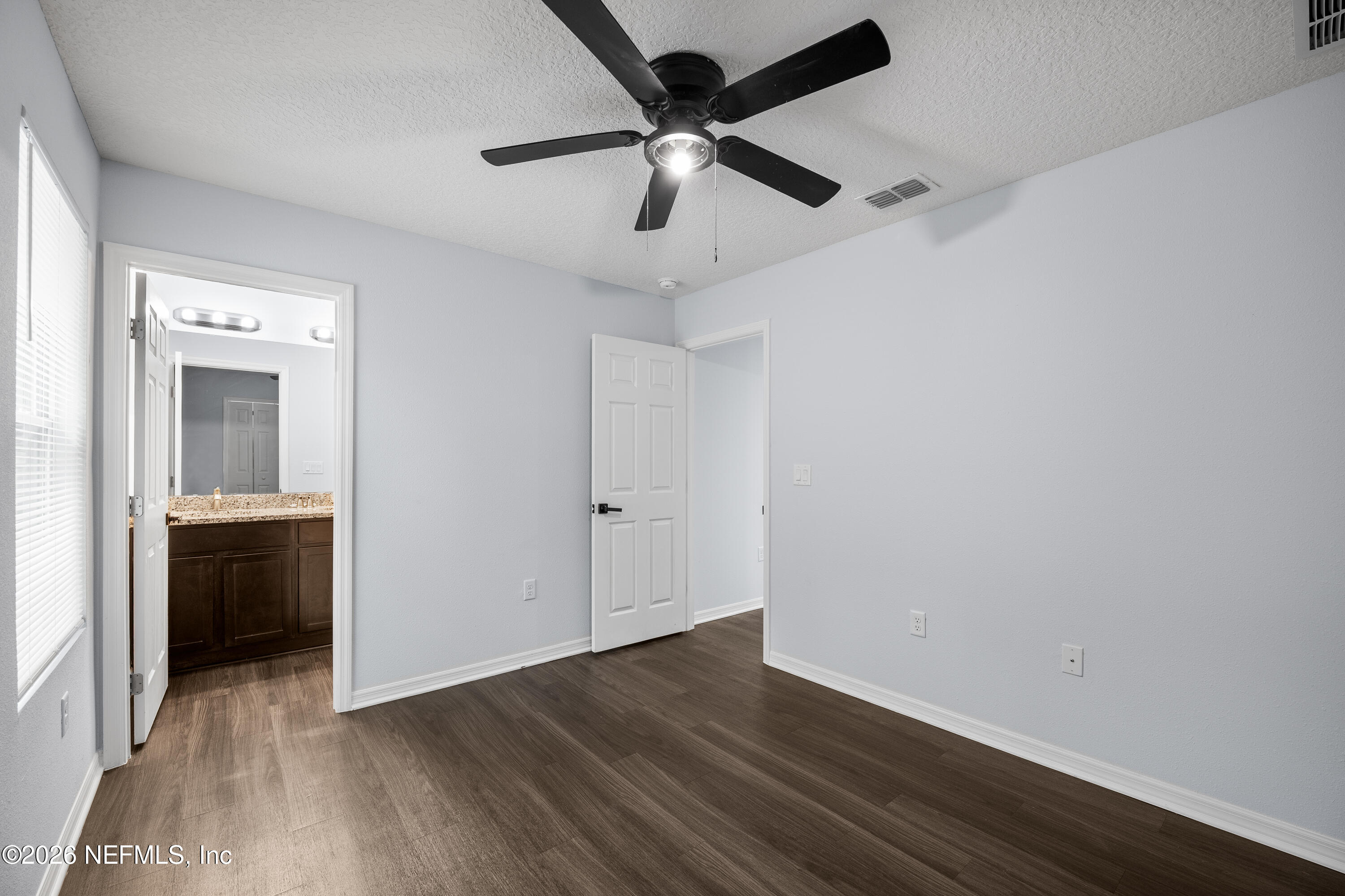 675 Moore Street Baldwin, FL 32234 - Photo 23 of 31 an empty room with wooden floor ceiling fan and windows