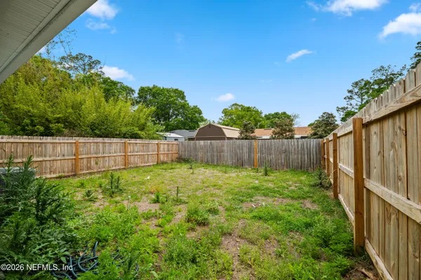 a view of a yard with wooden fence