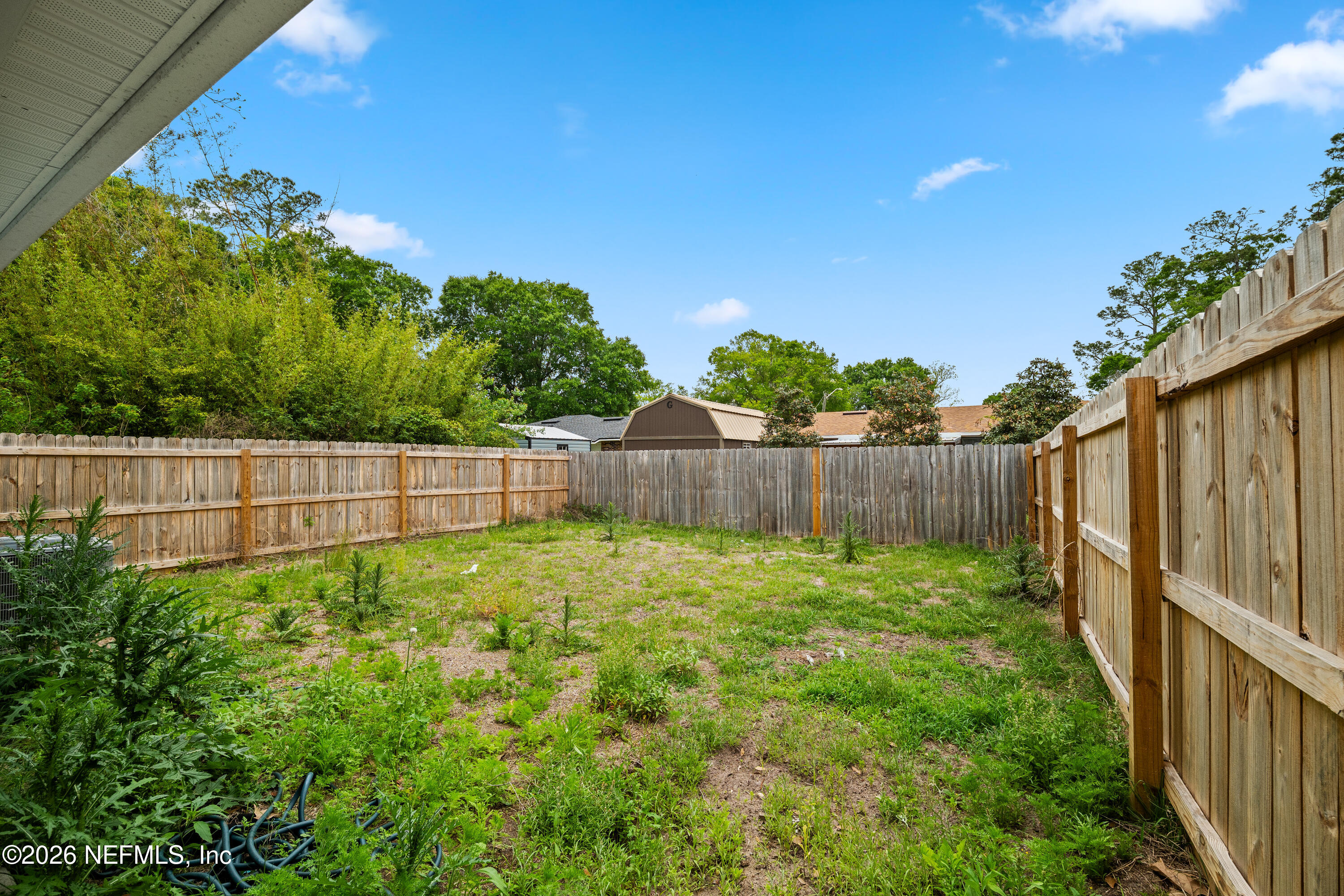 675 Moore Street Baldwin, FL 32234 - Photo 27 of 31 a view of a backyard with a plants and wooden fence