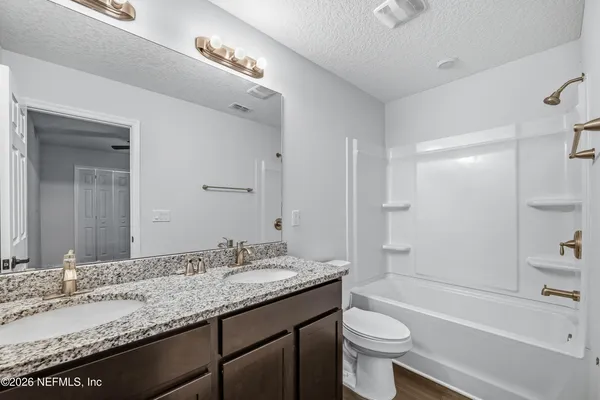 a bathroom with a granite countertop sink toilet and shower