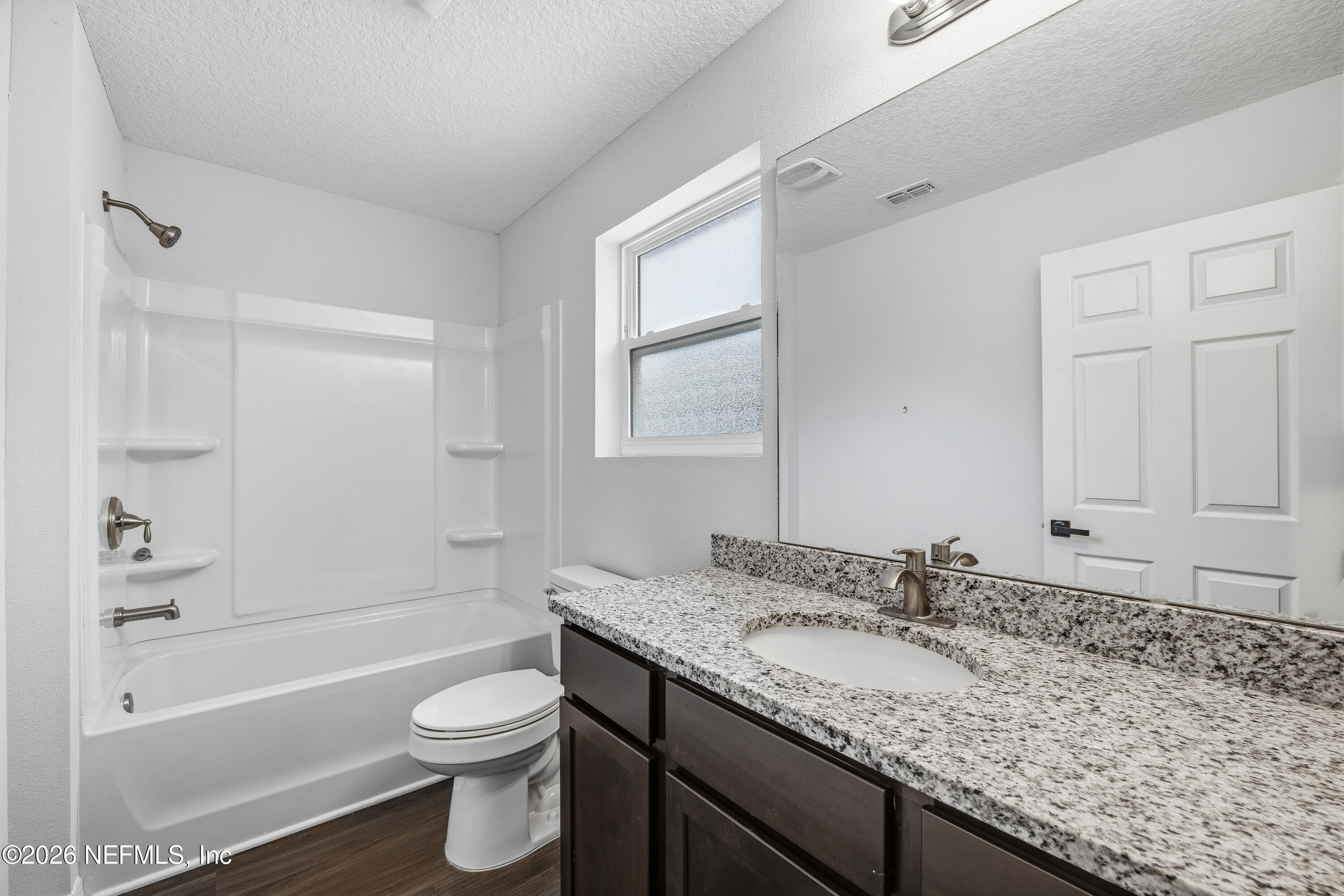 675 Moore Street Baldwin, FL 32234 - Photo 10 of 31 a bathroom with a granite countertop sink toilet and shower