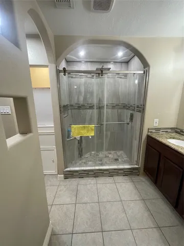 a bathroom with a glass shower door and a sink
