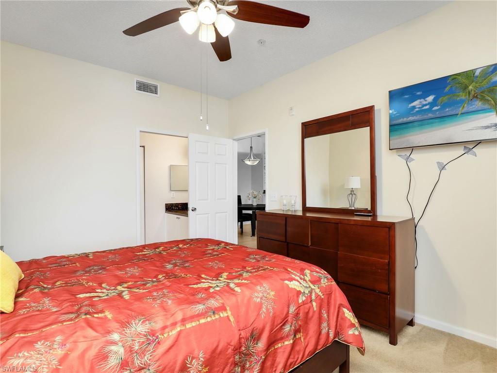 1205 Reserve Way, Unit 302 Naples, FL 34105 - Photo 17 of 31 a bedroom with a large bed and a dresser