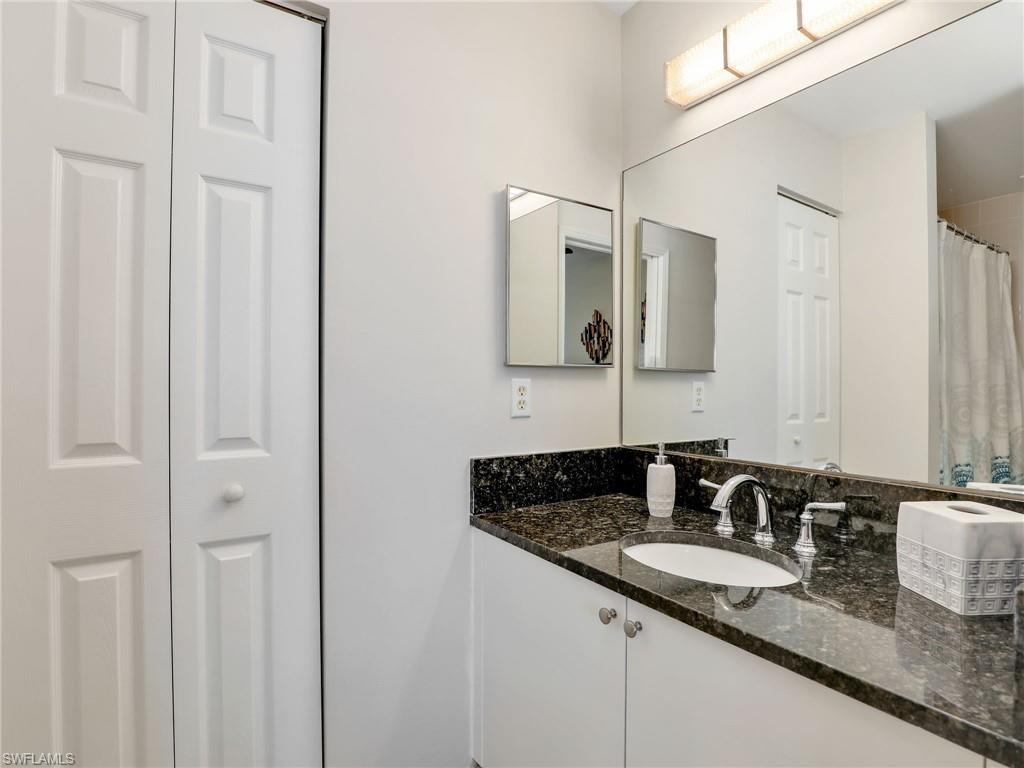 1205 Reserve Way, Unit 302 Naples, FL 34105 - Photo 18 of 31 a bathroom with a granite countertop sink and a mirror