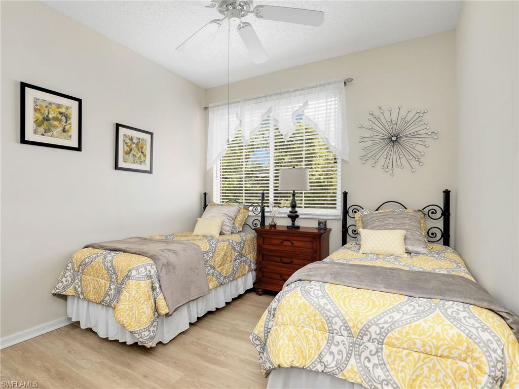 1205 Reserve Way, Unit 302 Naples, FL 34105 - Photo 19 of 31 a bed room with two bed and a chandelier