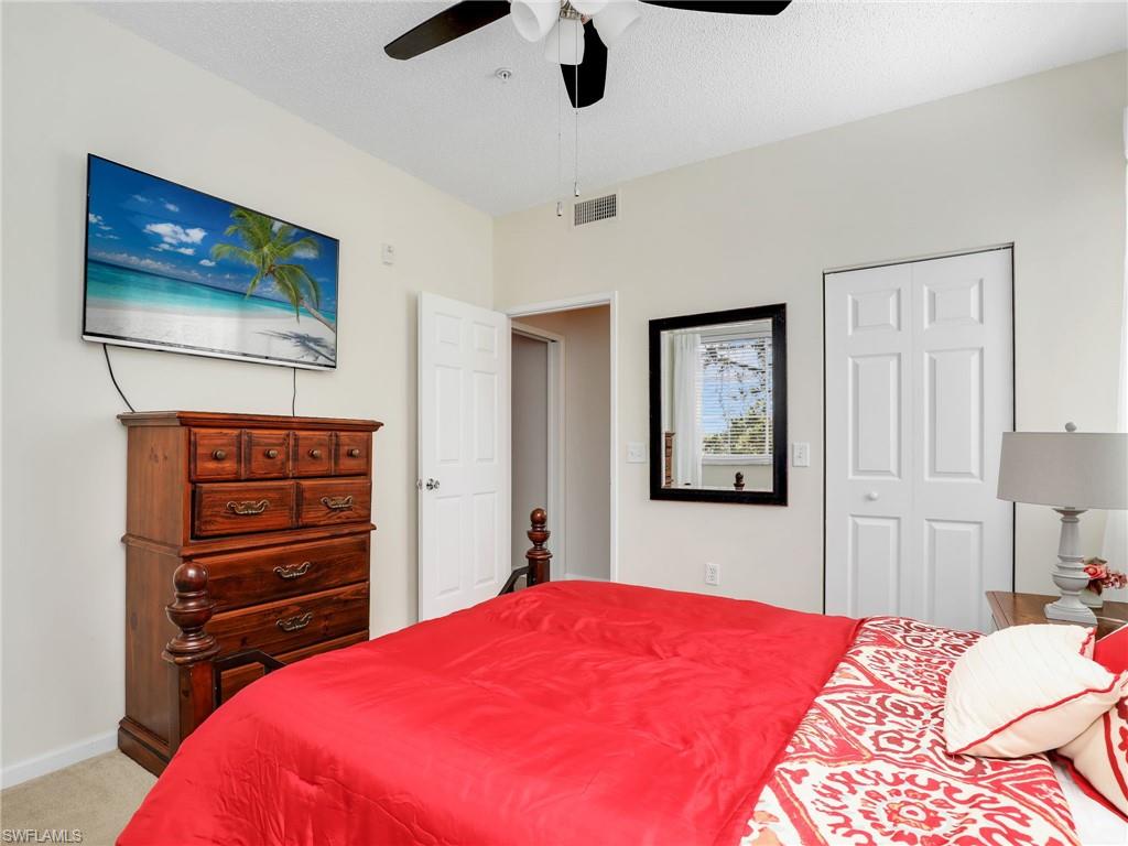 1205 Reserve Way, Unit 302 Naples, FL 34105 - Photo 22 of 31 a bedroom with a bed and a flat screen tv
