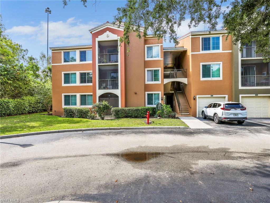 1205 Reserve Way, Unit 302 Naples, FL 34105 - Photo 3 of 31 a front view of a residential apartment building with a yard
