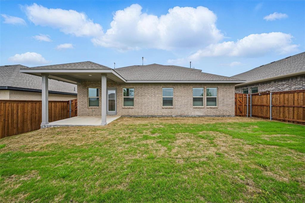 1413 Richardson Street Howe, TX 75459 - Photo 4 of 30 Rear exterior featuring a covered concrete patio, brick facade, and a wood privacy fence