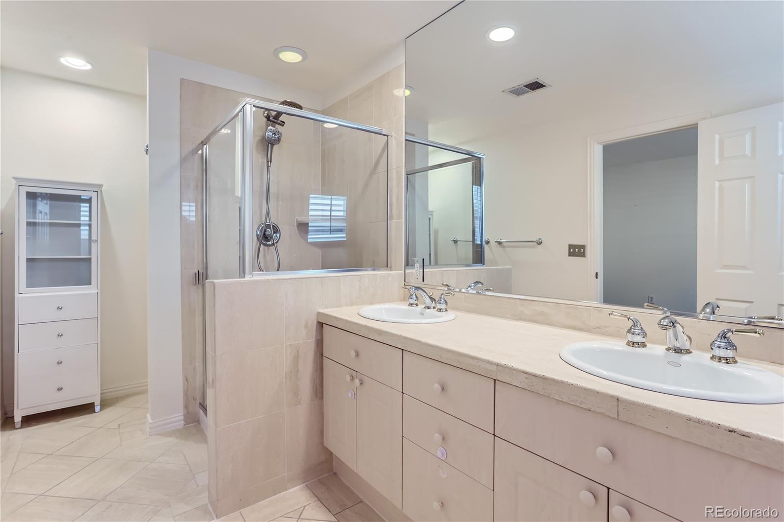 15 Jackson Street, Unit A Denver, CO 80206 - Photo 11 of 17 a bathroom with a double vanity sink a mirror and a shower