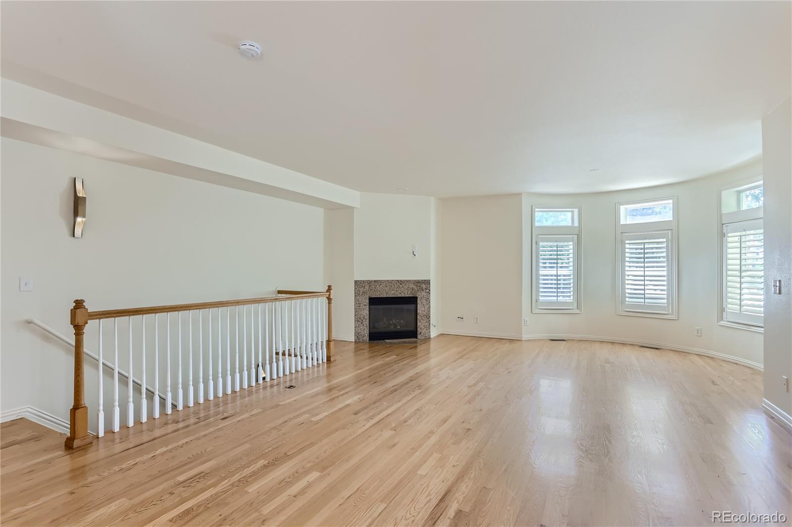15 Jackson Street, Unit A Denver, CO 80206 - Photo 2 of 17 a view of a bedroom with wooden floor fireplace and windows