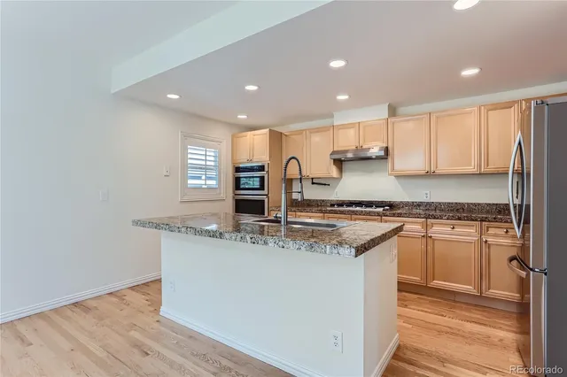 a kitchen with stainless steel appliances granite countertop a sink and a stove