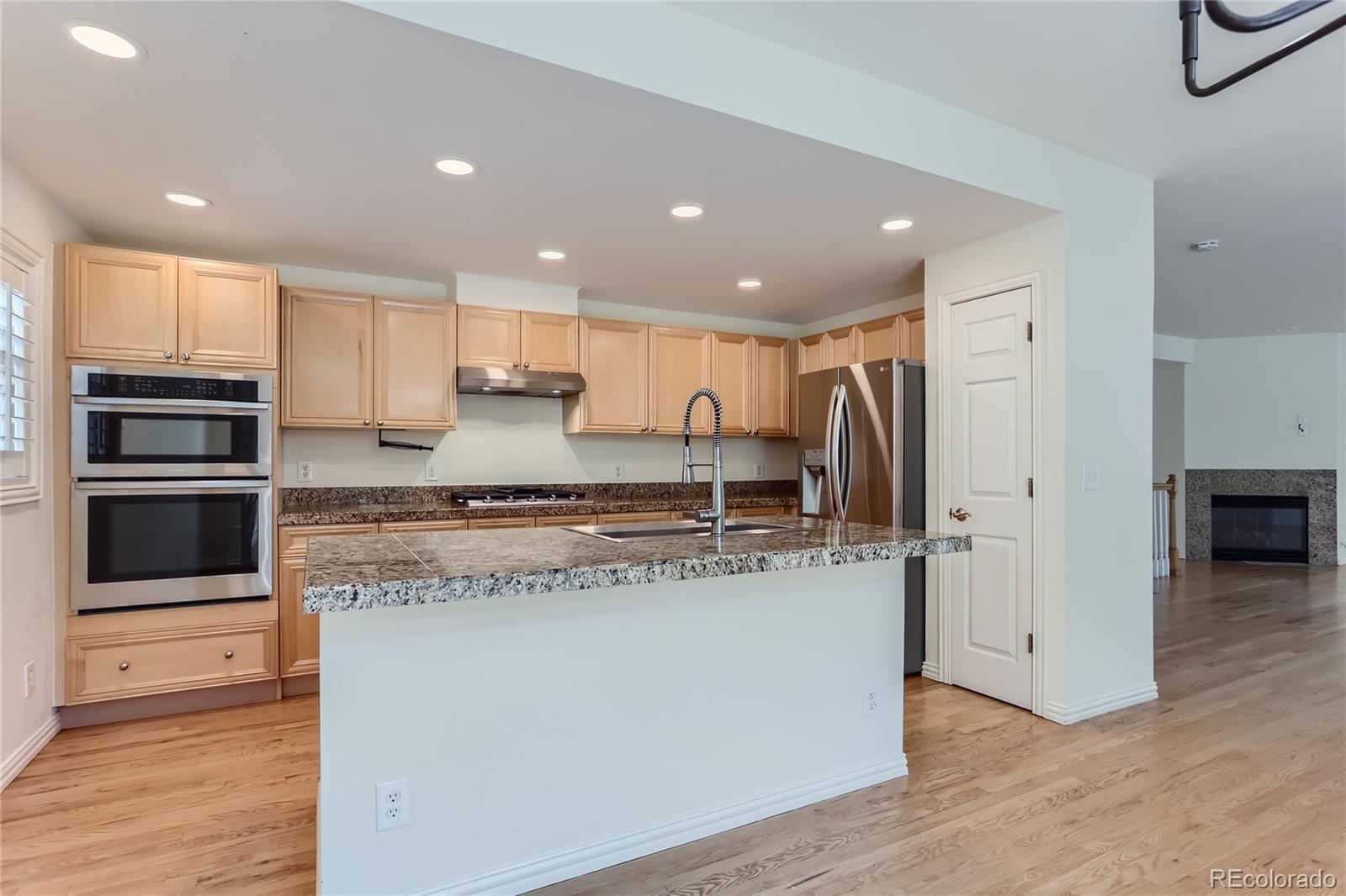 15 Jackson Street, Unit A Denver, CO 80206 - Photo 6 of 17 a large kitchen with stainless steel appliances granite countertop a stove a refrigerator and a sink