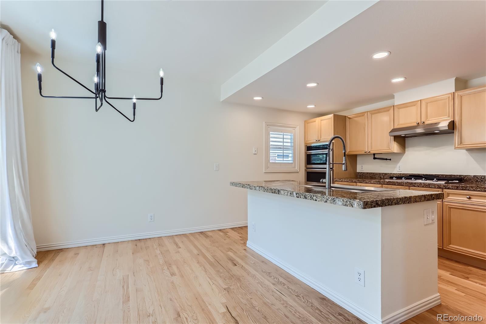 15 Jackson Street, Unit A Denver, CO 80206 - Photo 7 of 17 a kitchen with stainless steel appliances granite countertop a sink a stove and a refrigerator