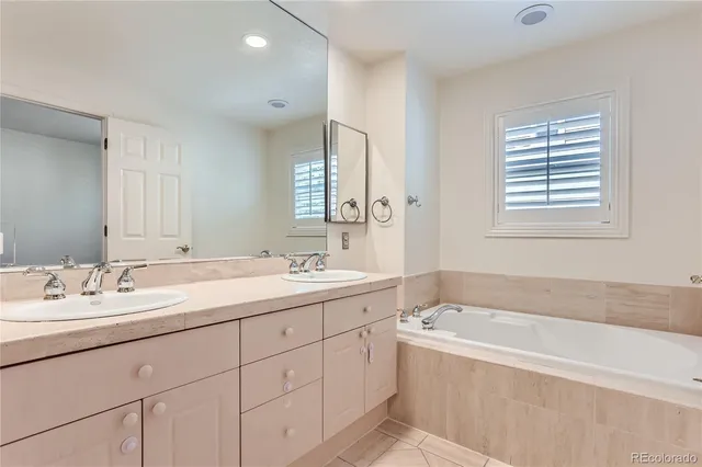 a spacious bathroom with a tub double sink window and mirror