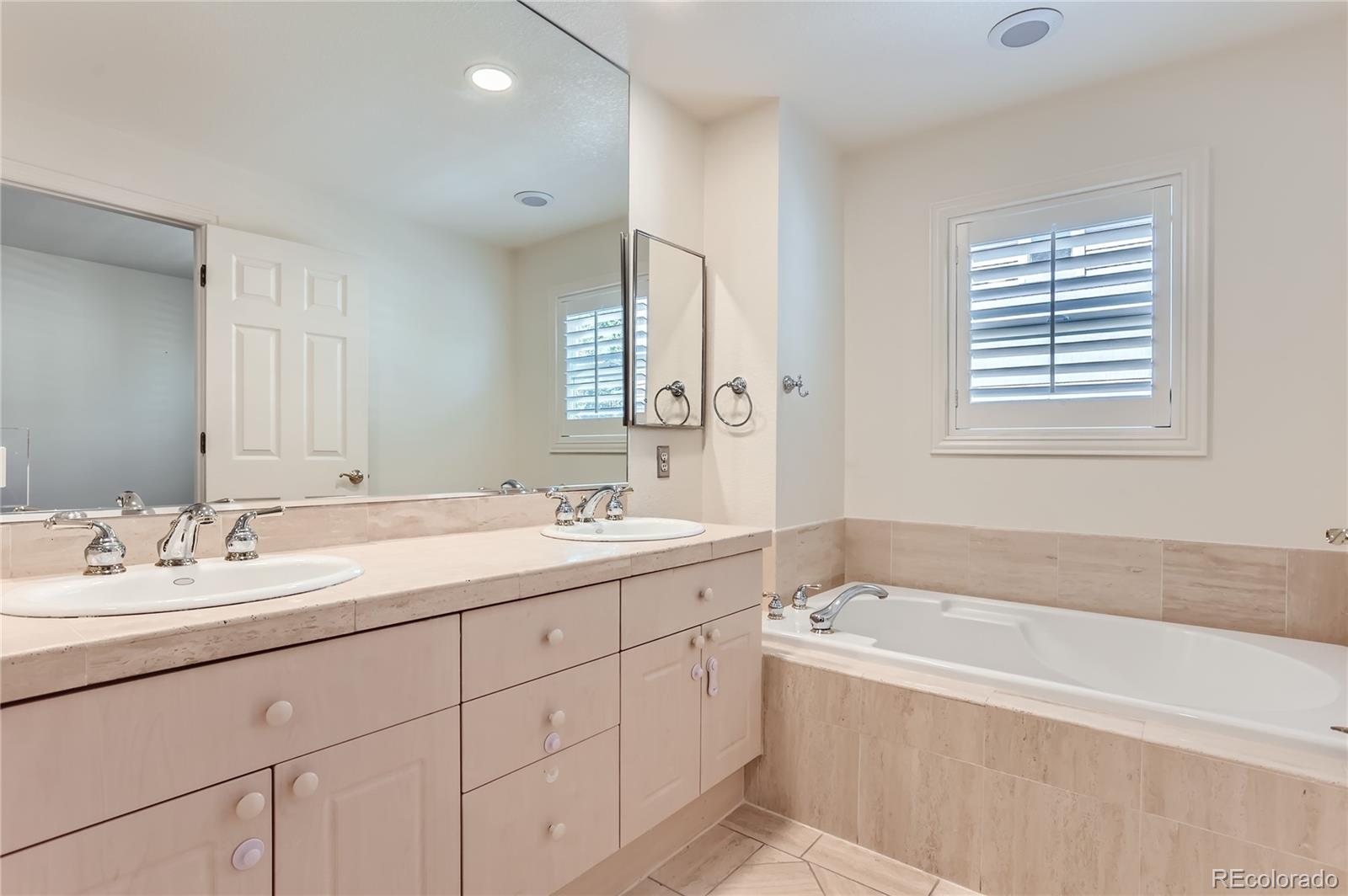 15 Jackson Street, Unit A Denver, CO 80206 - Photo 10 of 17 a spacious bathroom with a tub double sink window and mirror