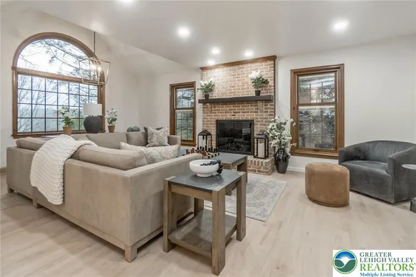 a living room with furniture a large window and a fireplace