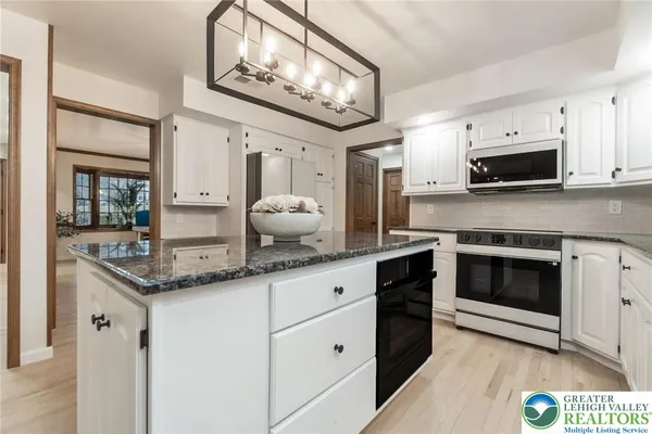 a kitchen with stainless steel appliances granite countertop a stove and cabinets