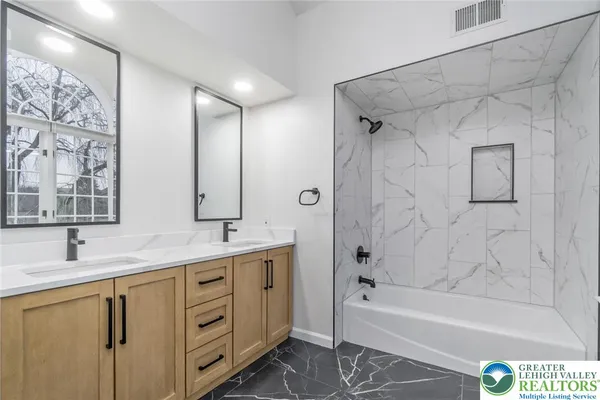 a bathroom with a tub sink and mirror