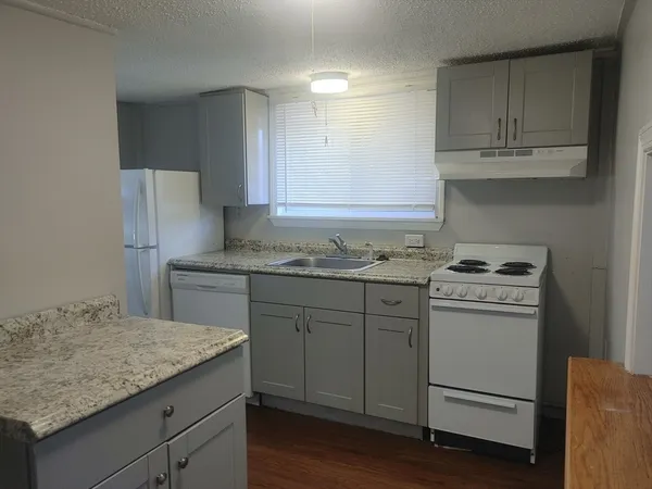 a kitchen with granite countertop cabinets stainless steel appliances and a sink