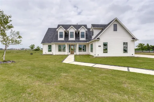 a front view of a house with a yard and lake view
