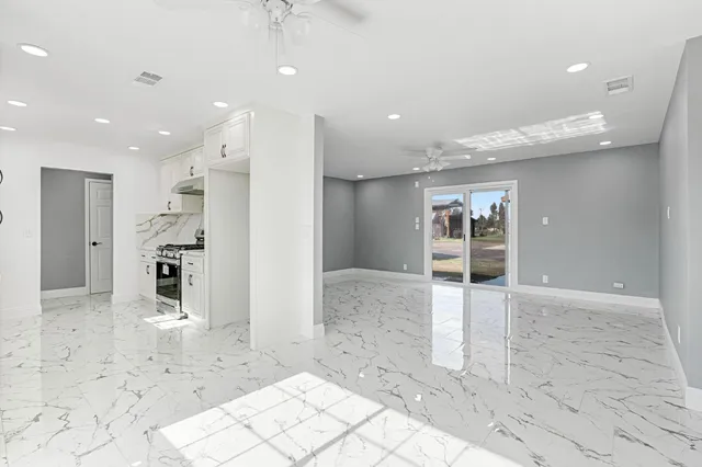 a view of a hallway with wooden floor and a refrigerator