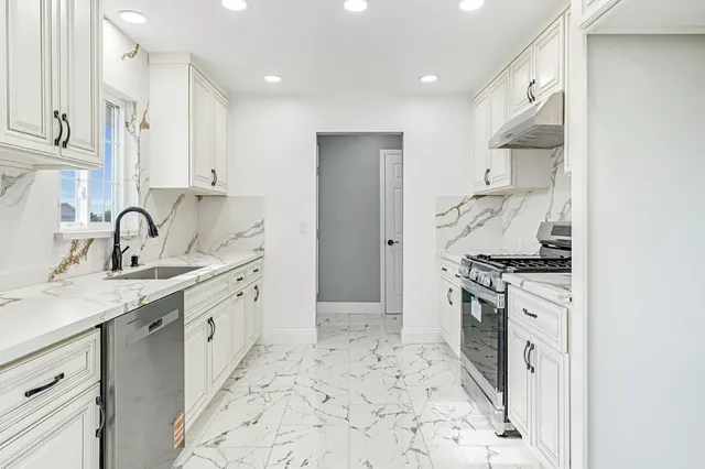 a kitchen with stainless steel appliances granite countertop a sink stove and refrigerator