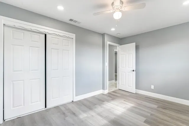 an empty room with fan and entrance