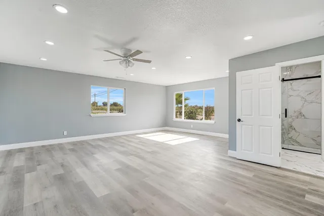 an empty room with fan and windows