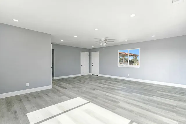 an empty room with wooden floor and window