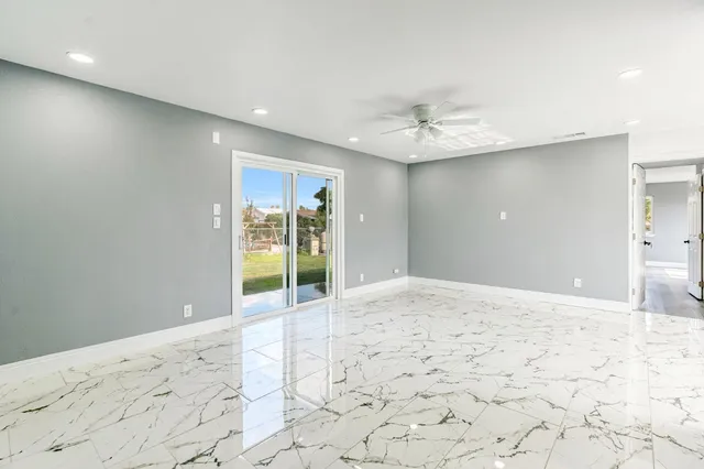 a view of a hallway with wooden floor and a ceiling fan
