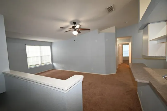 a view of a livingroom with a ceiling fan and window
