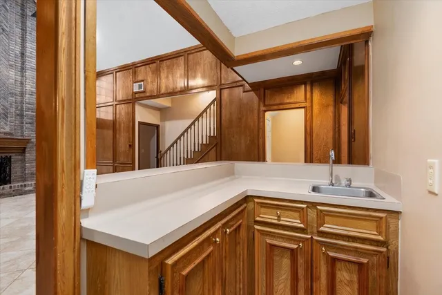 a kitchen with stainless steel appliances granite countertop a refrigerator a sink dishwasher a stove and a dining table with wooden floor