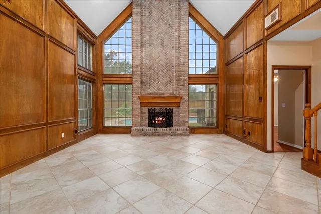 a view of an empty room with a fireplace and a window