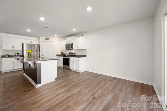 a kitchen with stainless steel appliances a refrigerator and a stove top oven