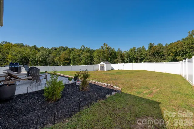 a garden with trees and wooden fence