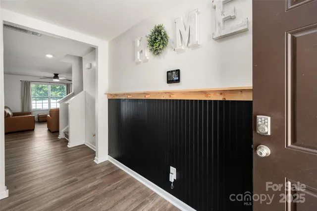 a view of a hallway with wooden floor and staircase