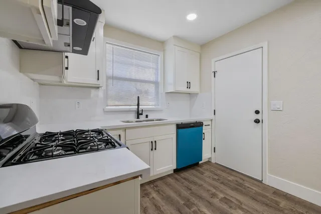 a kitchen with stainless steel appliances a sink stove and cabinets