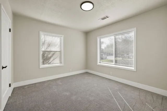an empty room with windows and closet
