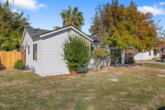 a view of a house with a yard and potted plants