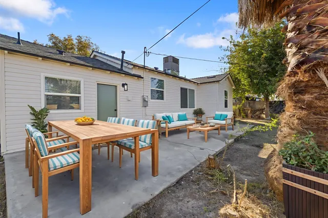 a backyard of a house with table and chairs