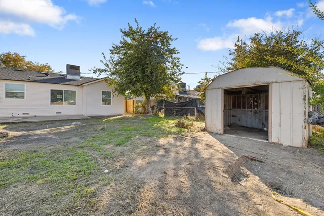 a view of a house with backyard and trees