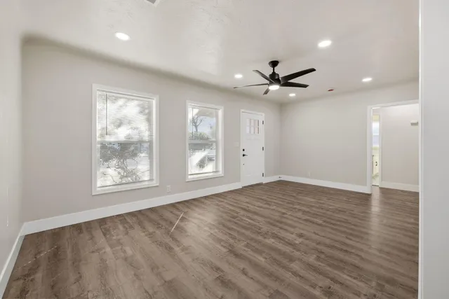 a view of an empty room with a window and a ceiling fan