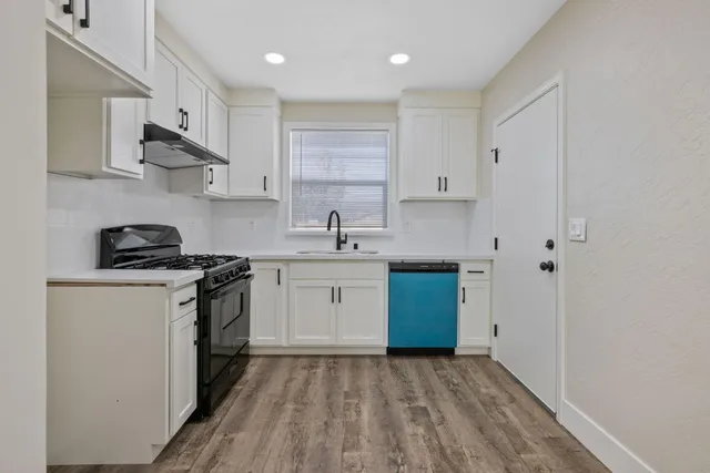 a kitchen with stainless steel appliances a sink stove and cabinets