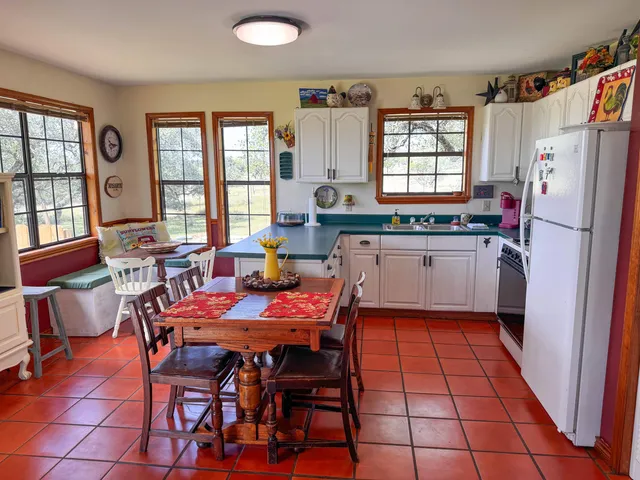 a kitchen with stainless steel appliances a table chairs and a refrigerator
