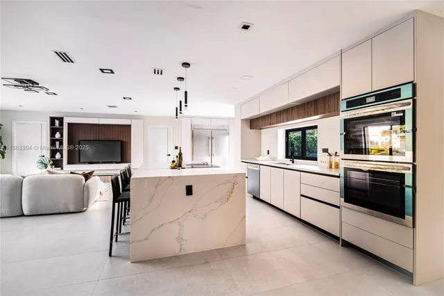 a large white kitchen with cabinets