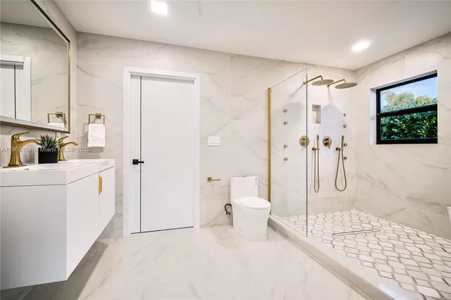 a bathroom with a sink a toilet and shower