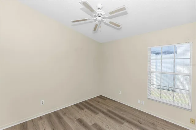 an empty room with windows and fan